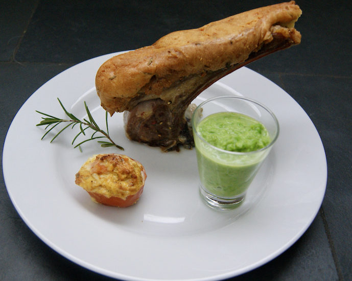Carré d’agneau en croûte de parmesan et romarin, purée de petits pois et tomates persillées