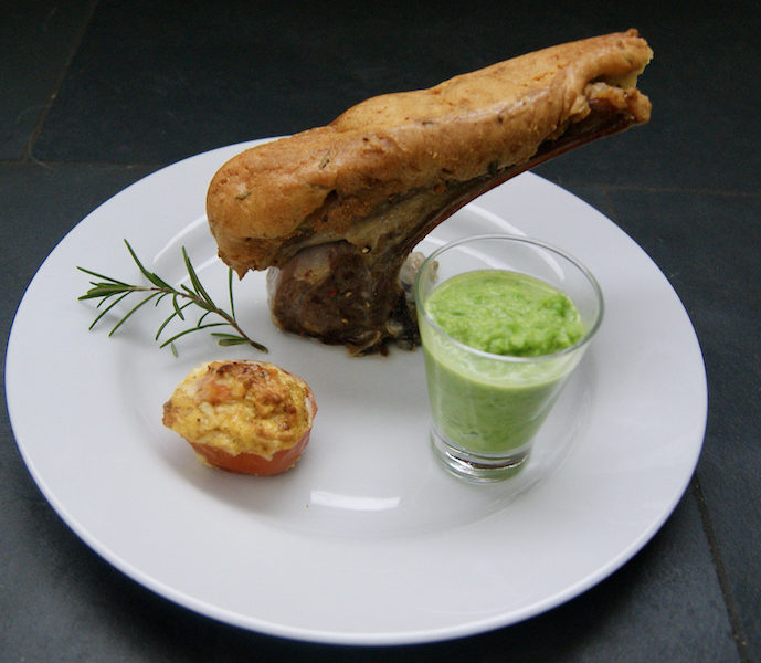 Carré d’agneau en croûte de parmesan et romarin, purée de petits pois et tomates persillées