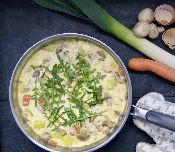 Omelette aux oignons, champignons, poireaux, carottes, lardons et roquette