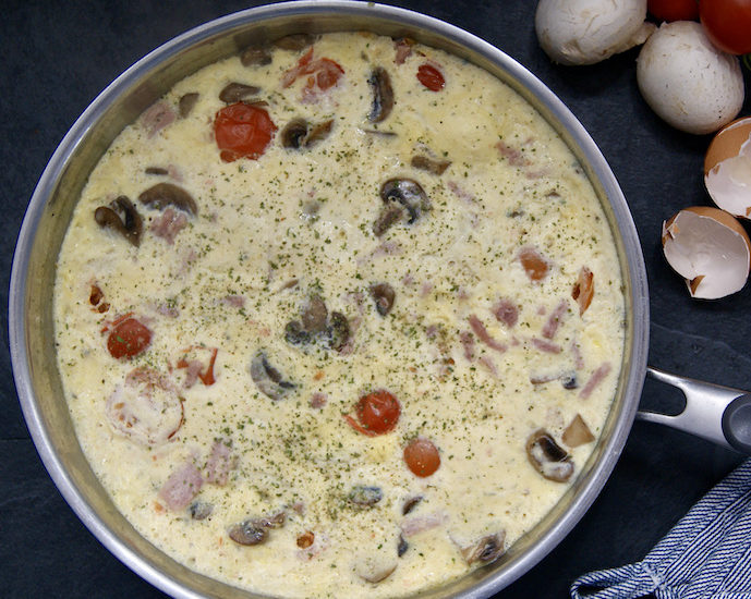 Omelette au jambon, tomates cerise et champignons