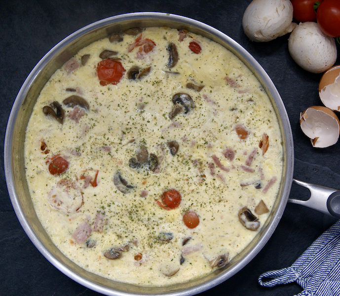 Omelette au jambon, tomates cerise et champignons